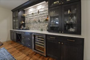 custom wet bar with alcohol storage and black cabinets